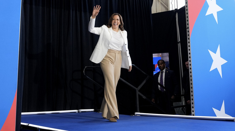 Kamala Harris smiling and waving as she walks on stage