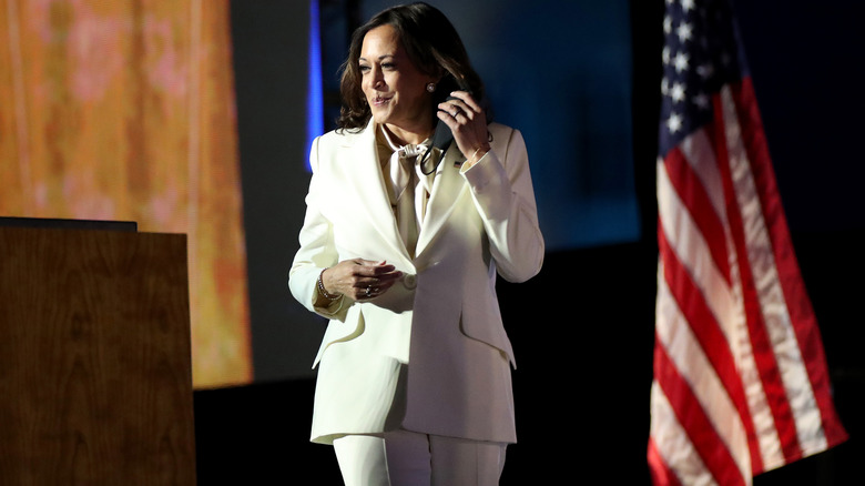 Kamala Harris walking on stage ion white suit