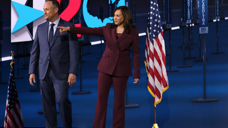 Doug Emhoff standing next to Kamala Harris pointing on stage