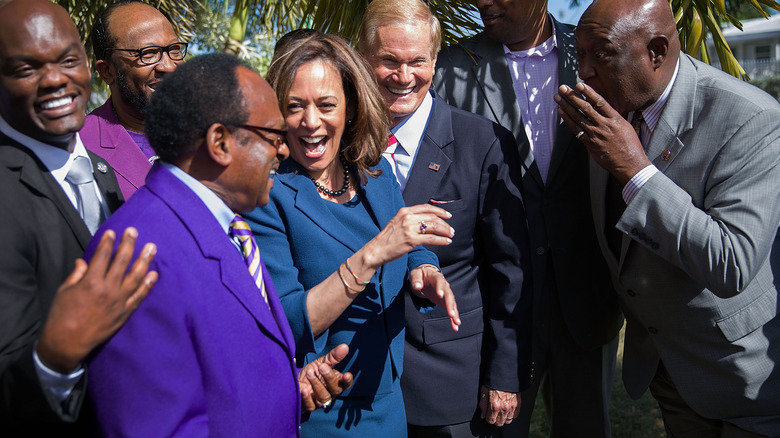 Kamala Harris laughing with Bill Nelson and men