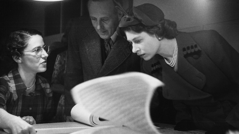 Queen Elizabeth examining stamps 