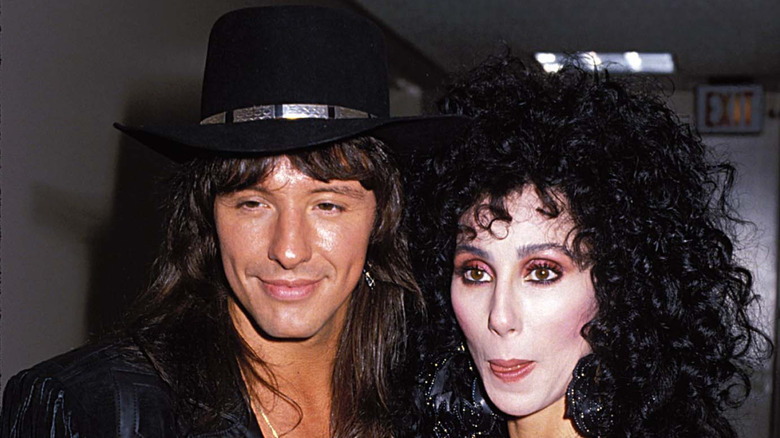 Richie Sambora in black hat and Cher with curly black hair