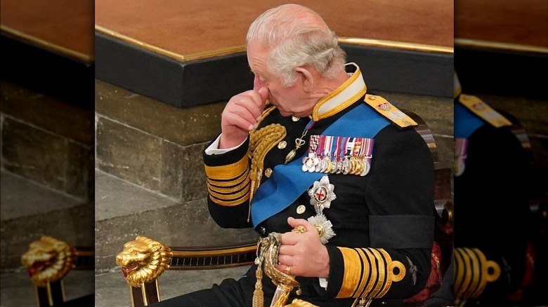 King Charles III wipes away a tear