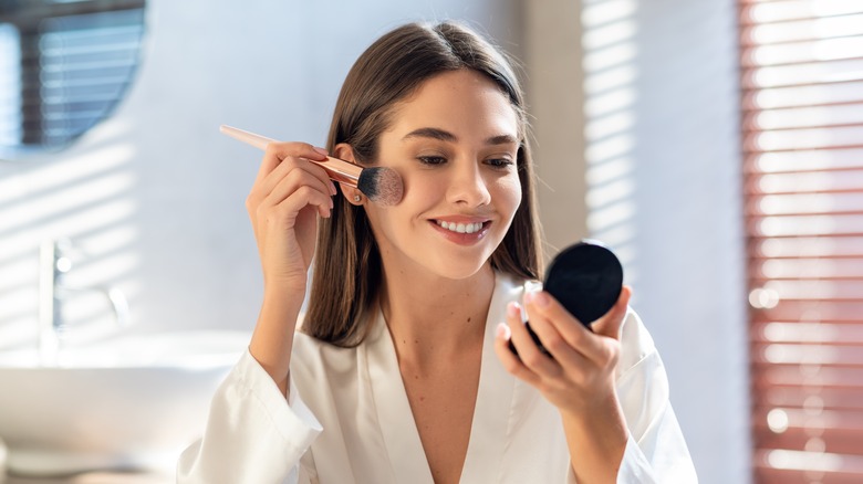 Woman smiling doing makeup