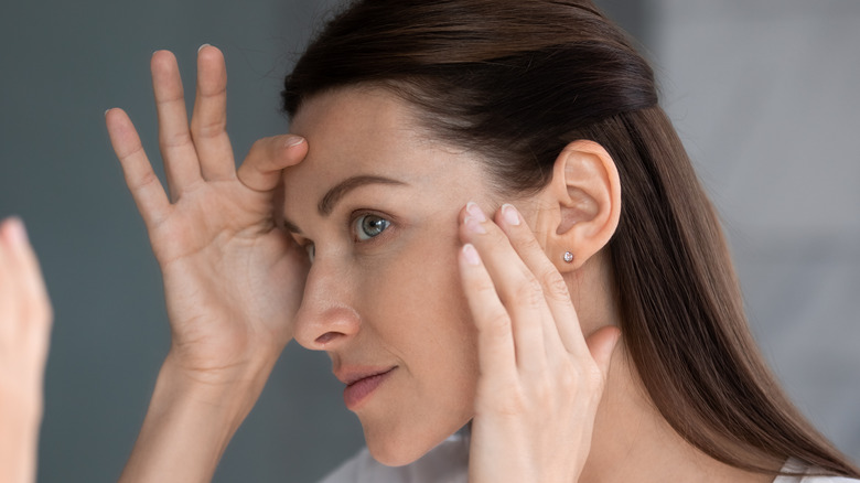 woman examining the face