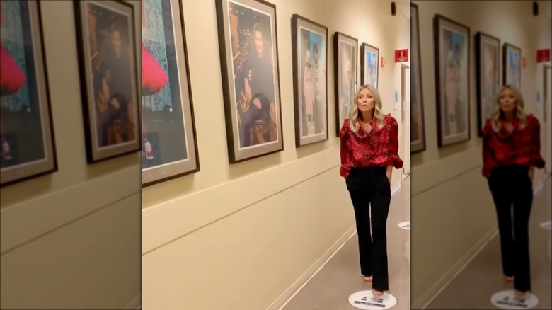 Kelly Ripa walking with hands in pockets