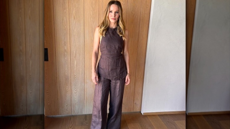 Kristen Bell posing at home in a wrinkled linen jumpsuit