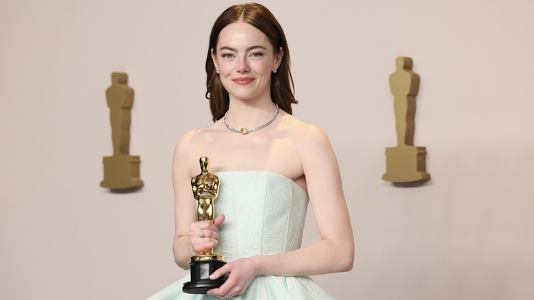 Emma Stone holds her Oscar for her performance in 