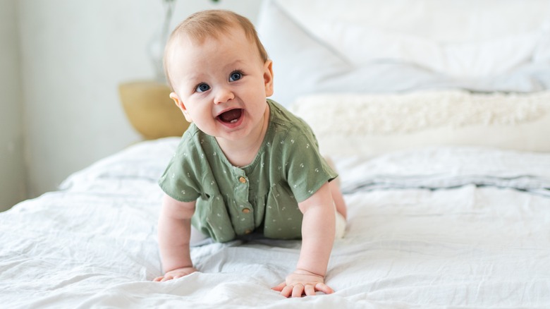 Baby crawling on a bed