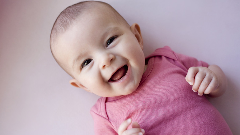 Baby laughing in pink onesie