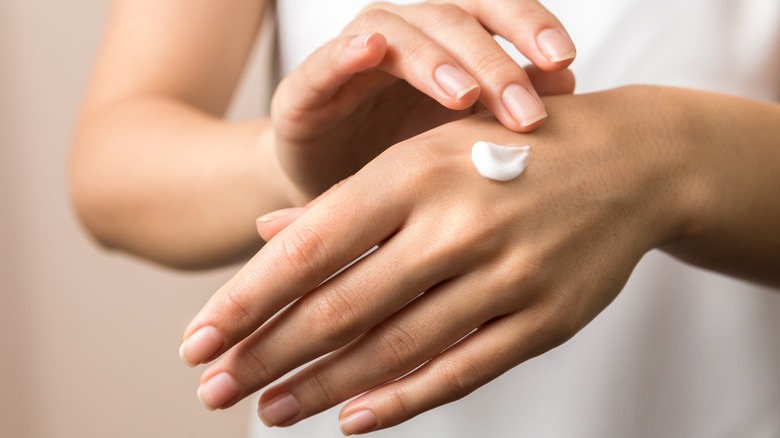 Woman applying lotion to hand