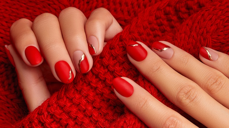 Red nail manicure holding red sweater