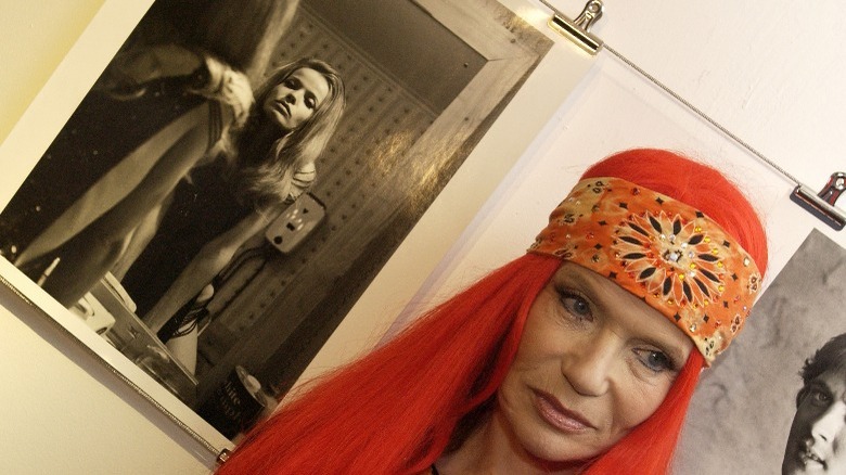 Veruschka in red wig near an old photo of her