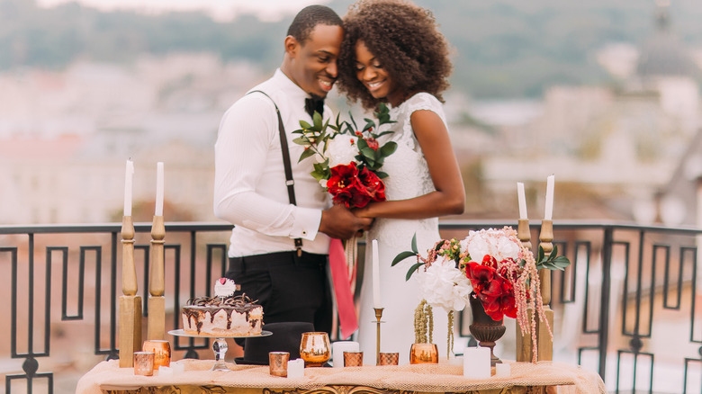 couple holding bridal bouquet outside 