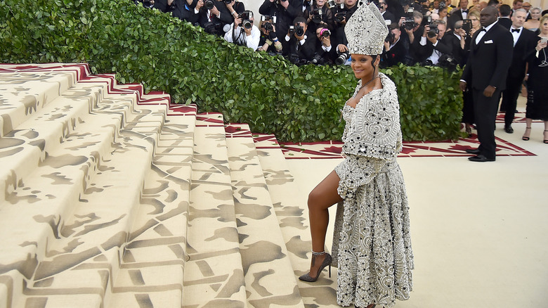 Rihanna smiling and posing for a photo at the Met Gala