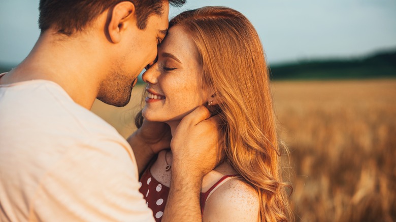 Couple kissing in a field 