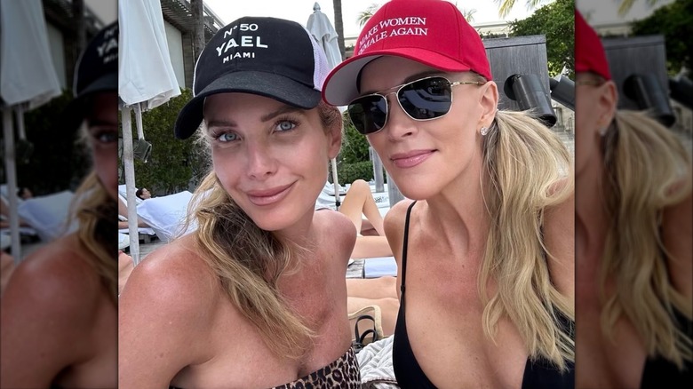 Megyn Kelly with a friend outside at a pool, wearing a red baseball cap with a slogan.