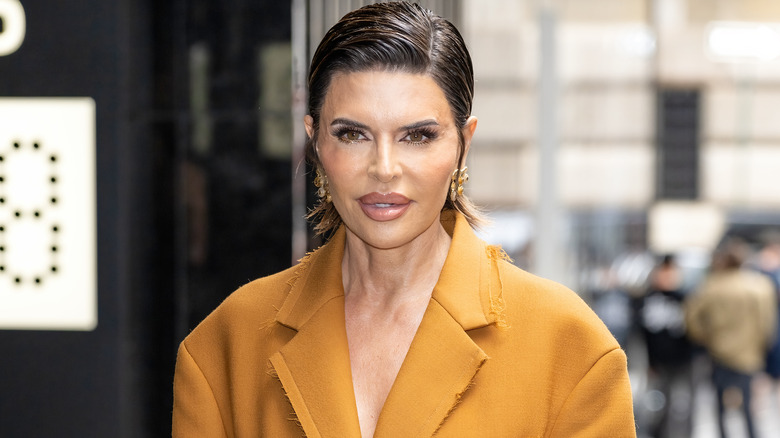 Lisa Rinna posing on street in yellow coat