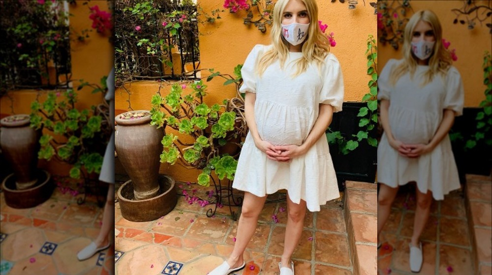 Emma Roberts in a white dress, visibly pregnant