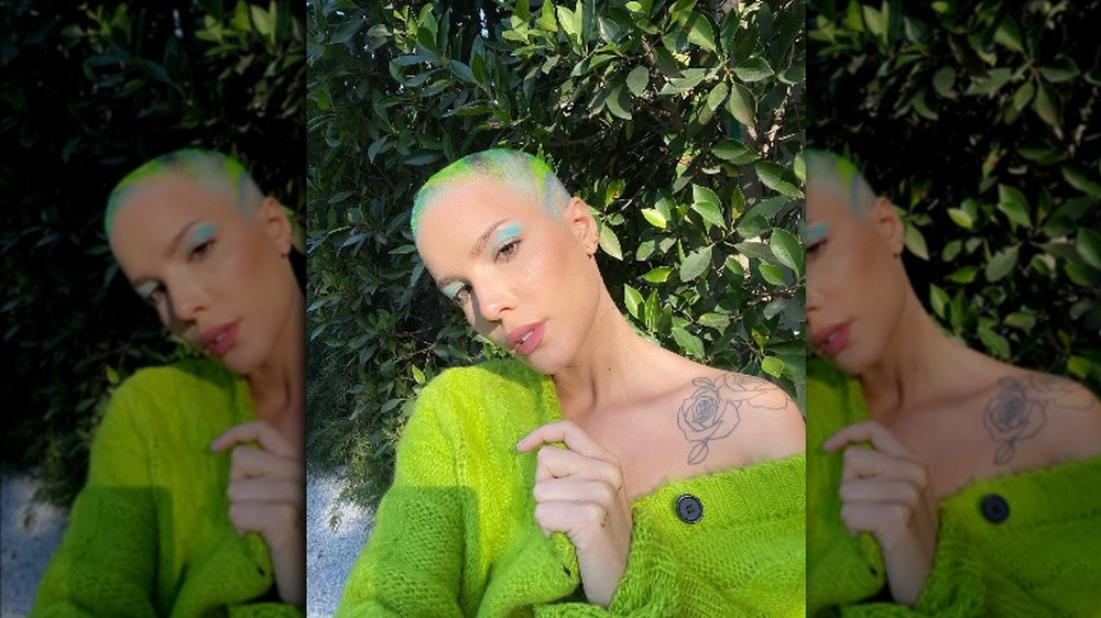 Halsey with a shaved head wearing green