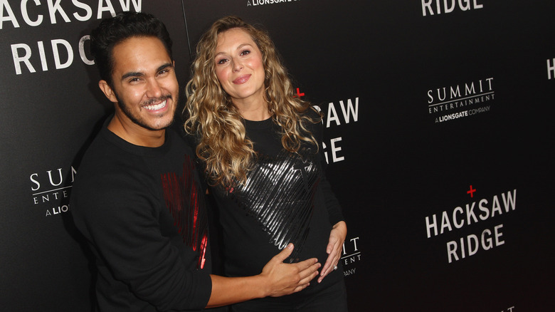 Carlos PenaVega with hand on wife Alexa PenaVega's baby bump