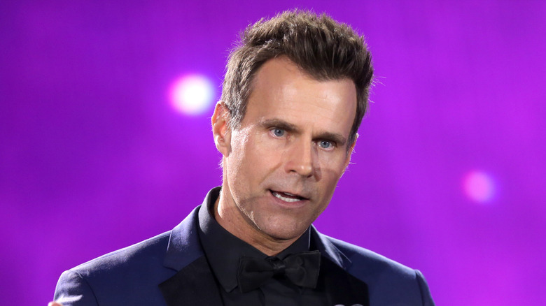 Cameron Mathison giving a speech in front of a purple background