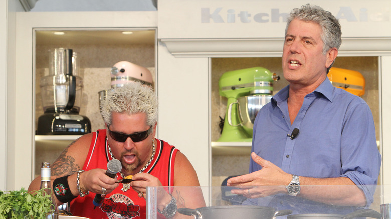 Guy Fieri cooking beside Anthony Bourdain