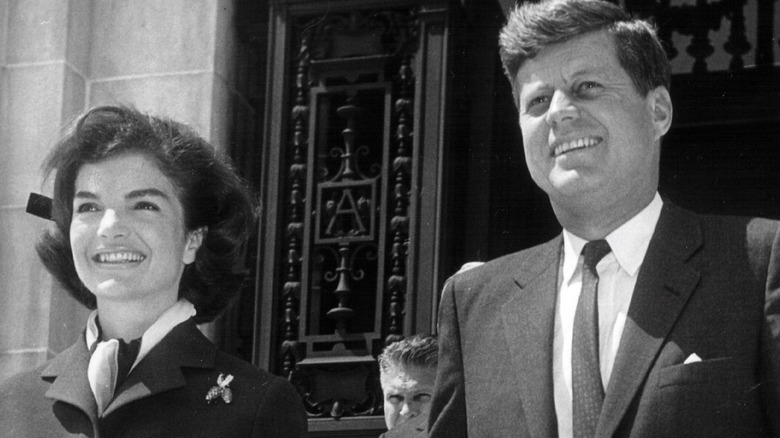 Jackie Kennedy and JFK standing and smiling