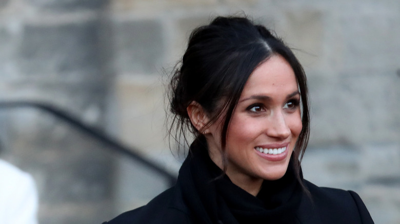 Meghan Markle in navy coat and messy bun