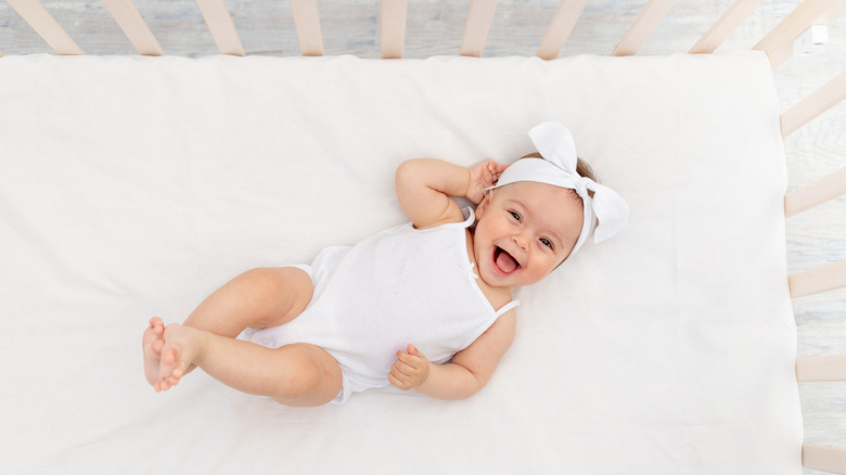 baby girl smiling in crib 