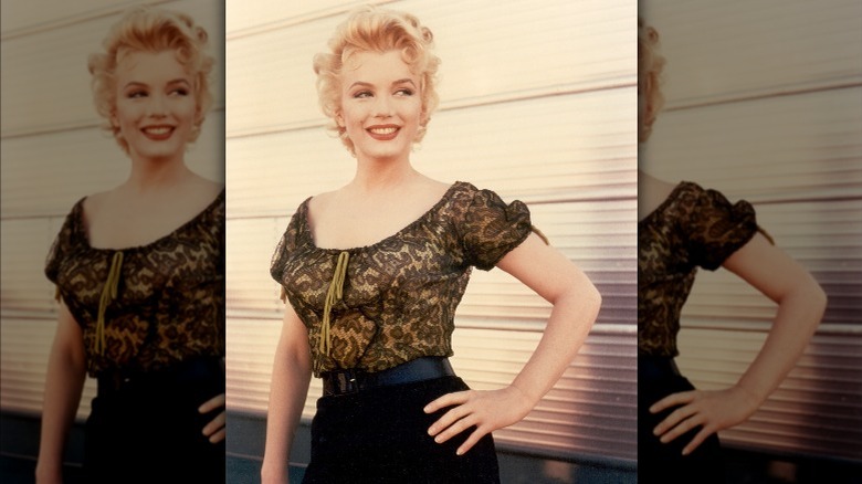 Marilyn Monroe with her left hand on her hip, poses for a photo