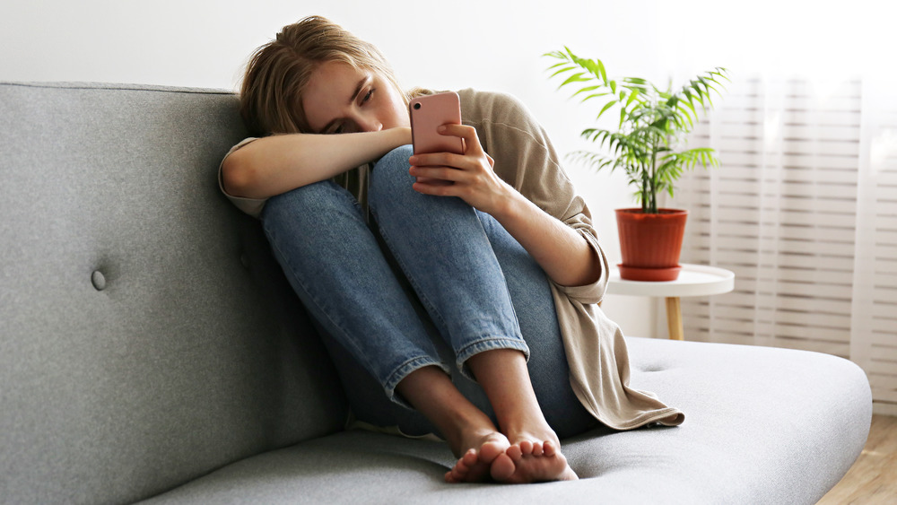 Sad woman looking at phone