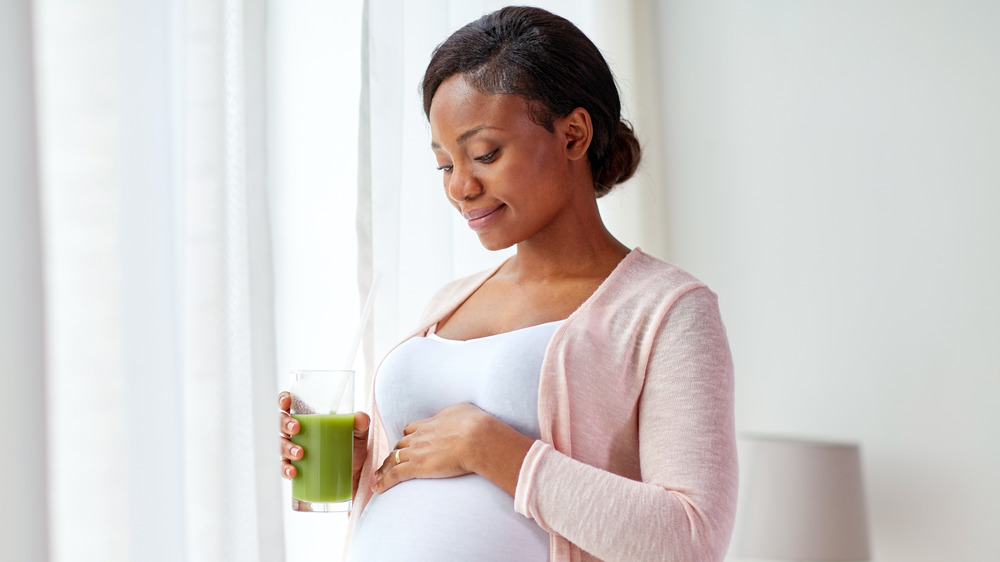 Pregnant woman holding a glass of juice