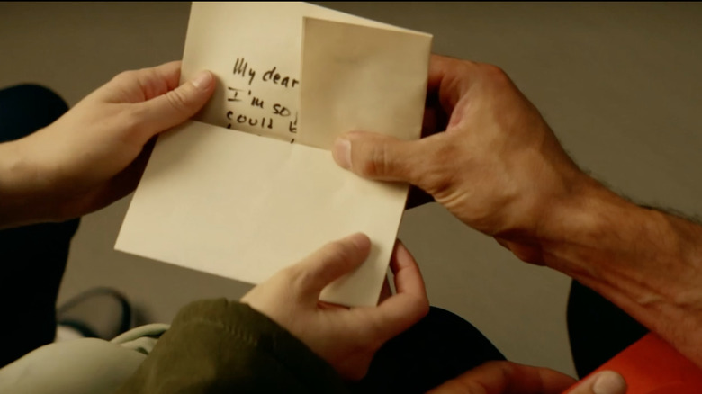 two hands holding letter from Reindeer Games Homecoming