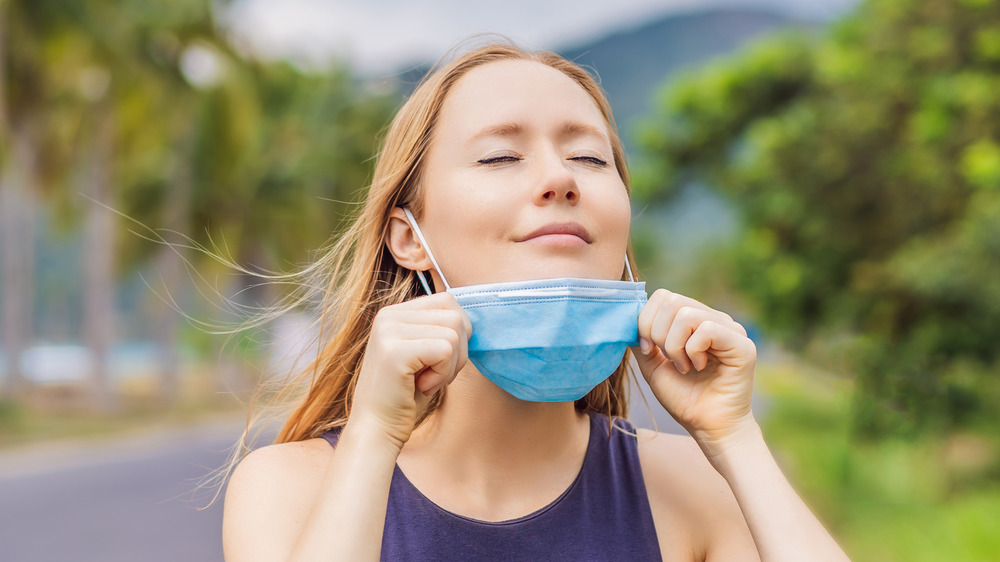 woman removing face mask