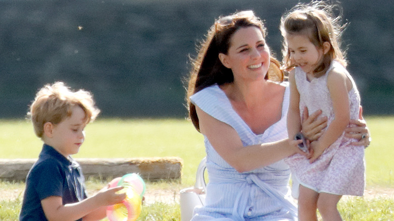 Kate Middleton sits on the grass with her kids 