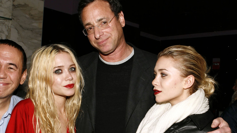 Bob Saget embracing Mary-kate and Ashley Olsen at event 