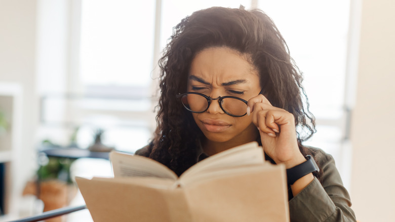 Woman squinting at book