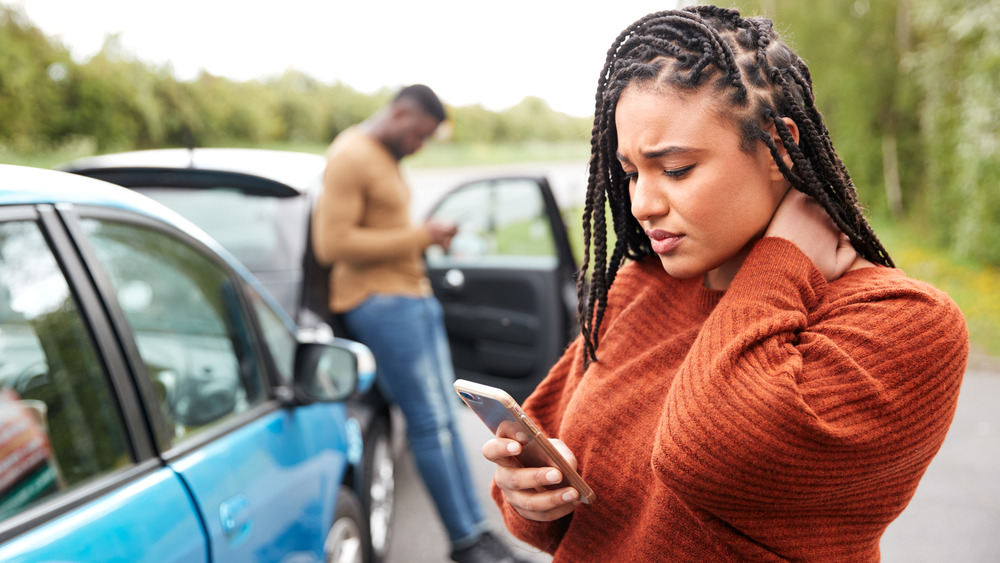 Girl wearing orange sweater, holding phone