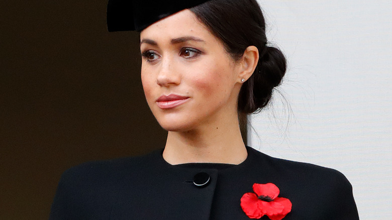 Meghan Markle wearing black and a poppy