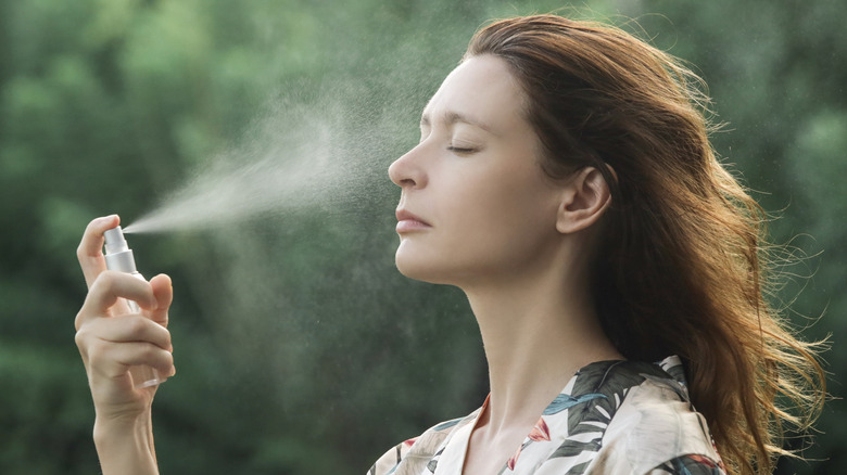 Woman spraying facial spray on face