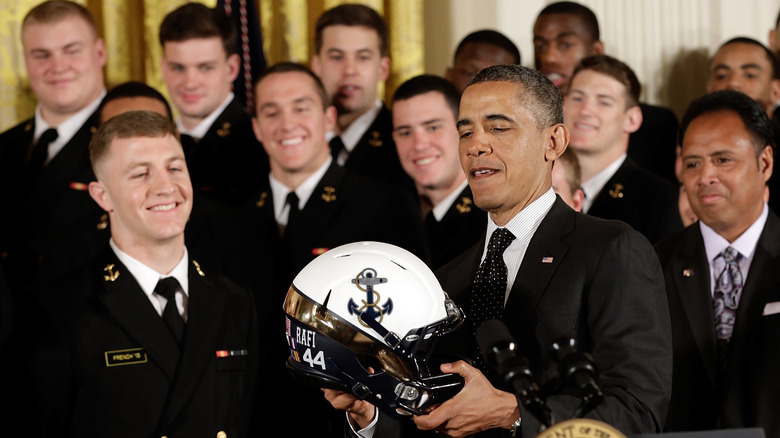 President Barack Obama admiring a football helmet