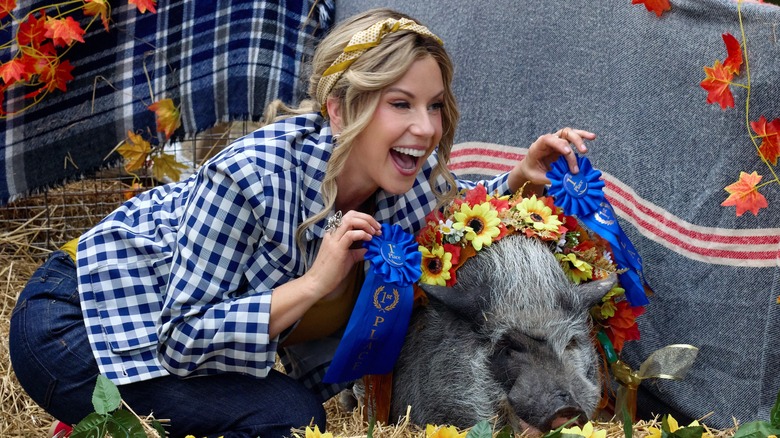 Jodie Sweetin smiling with a pig