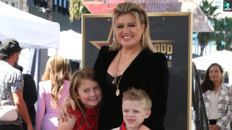 Kelly Clarkson holds her son Remy Blackstock, while standing next to her daughter, River Rose