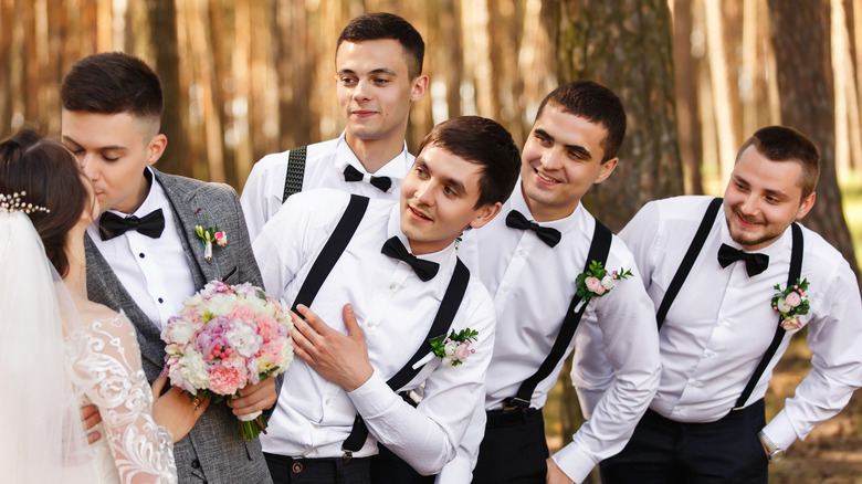 Groomsmen look at the bride and groom