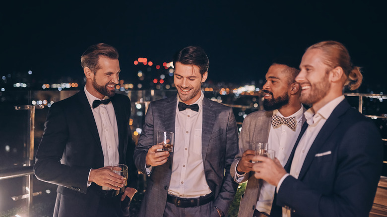 Groomsmen smile on a rooftop