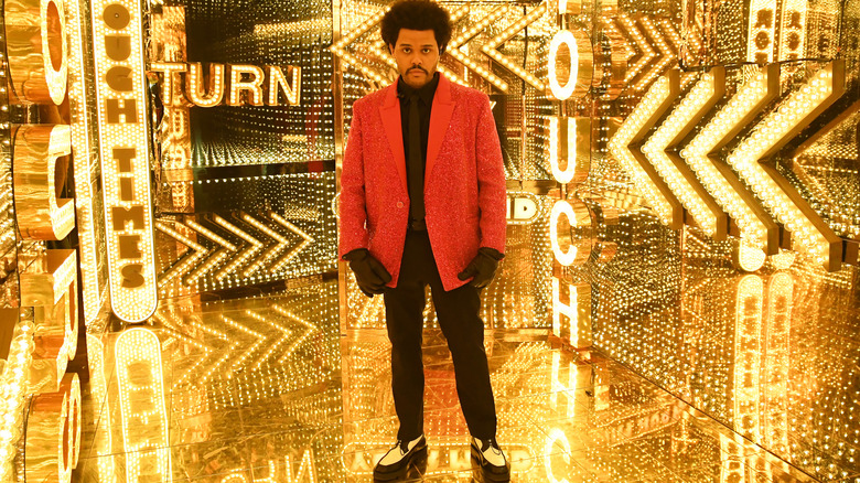 The Weeknd looks sad in a room of gold mirrors