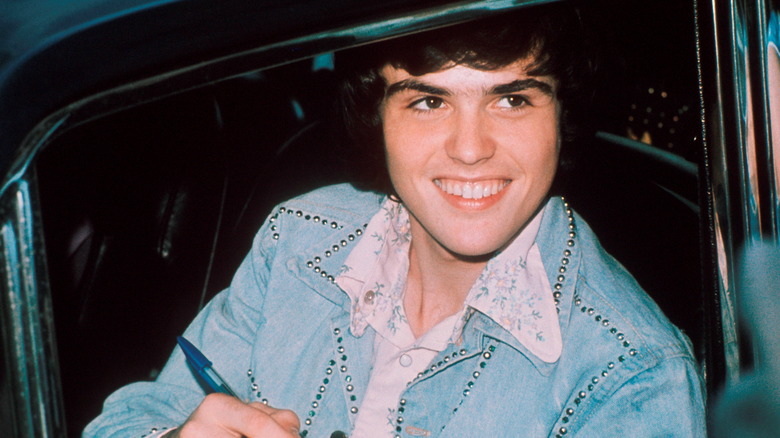 Donny Osmond smiling while seated in a car 