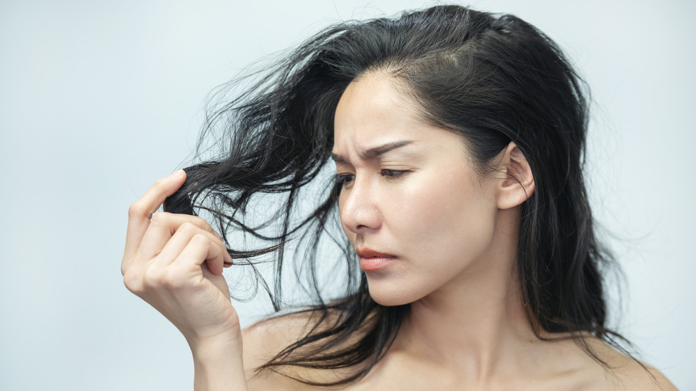 Woman examining hair for signs of loss