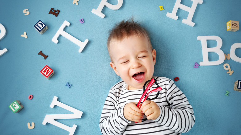 Baby boy surrounded by letters